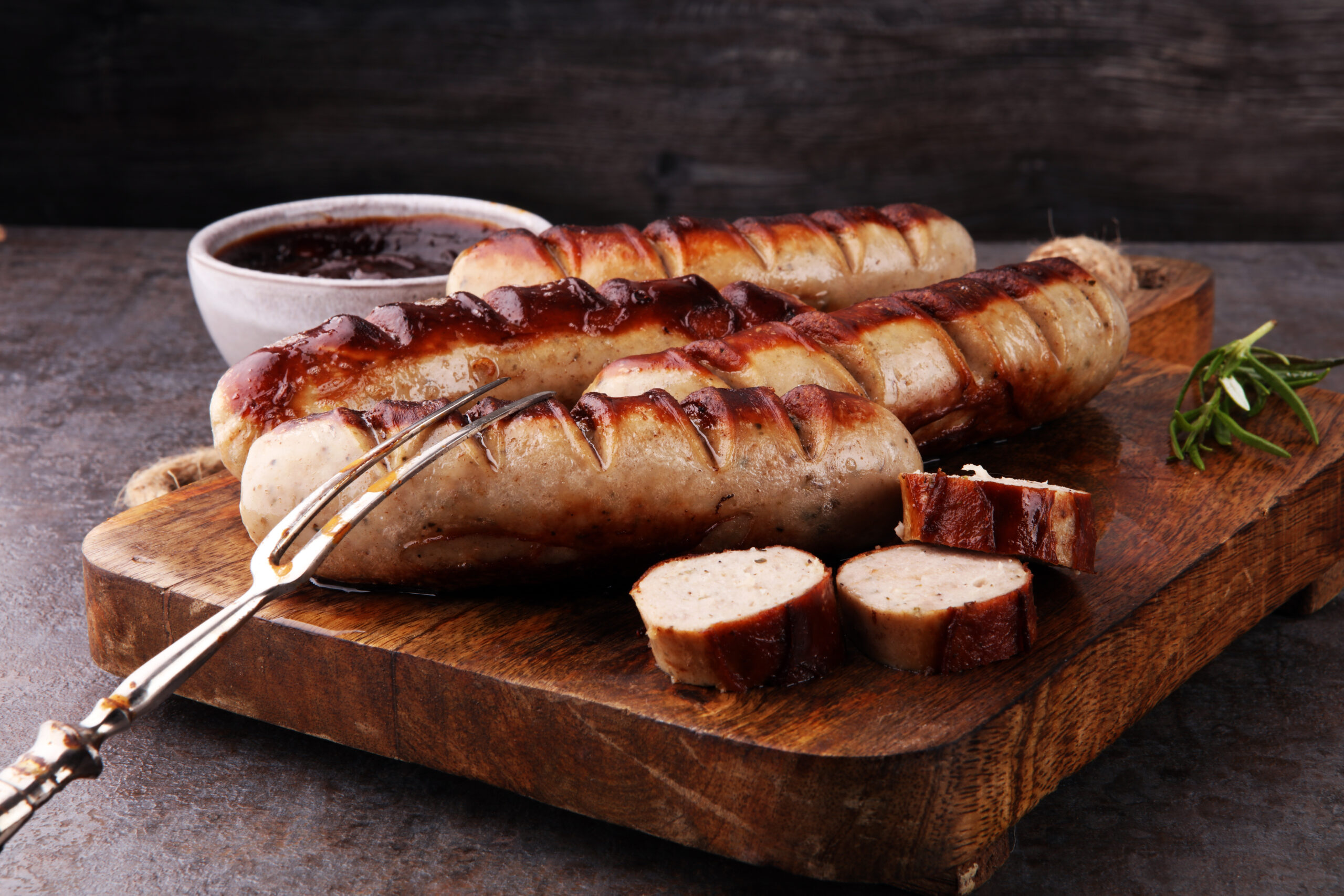 Gegrillte Bratwürste mit Ketchup auf einem Holztisch
