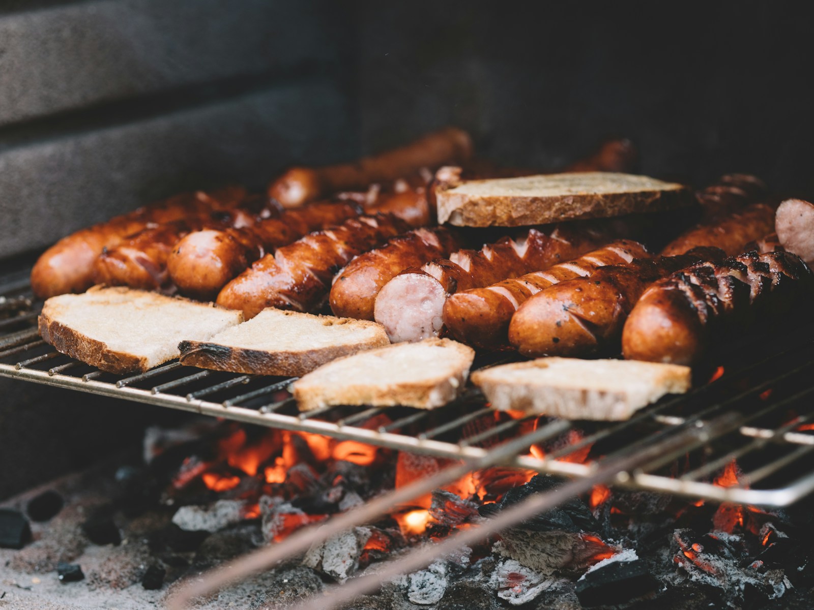 Gegrillte Bratwürste und Brot auf dem Rost