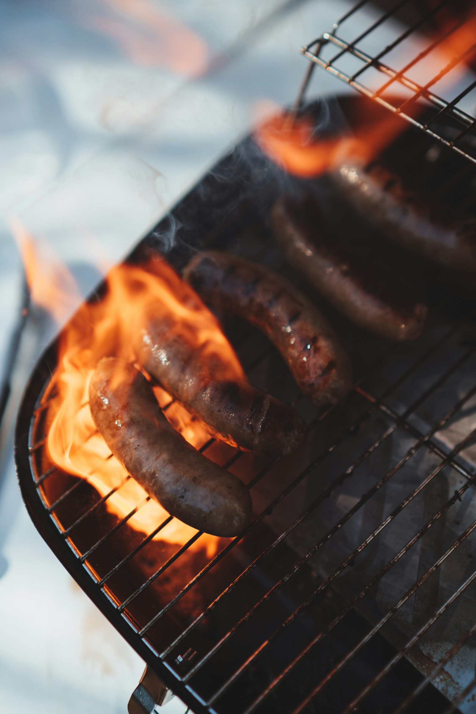 Mehrere Bratwürste auf einem heißen Grillrost
